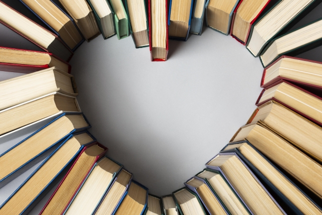 Książki ułożone w kształt serca, stoją oparte o siebie bokami